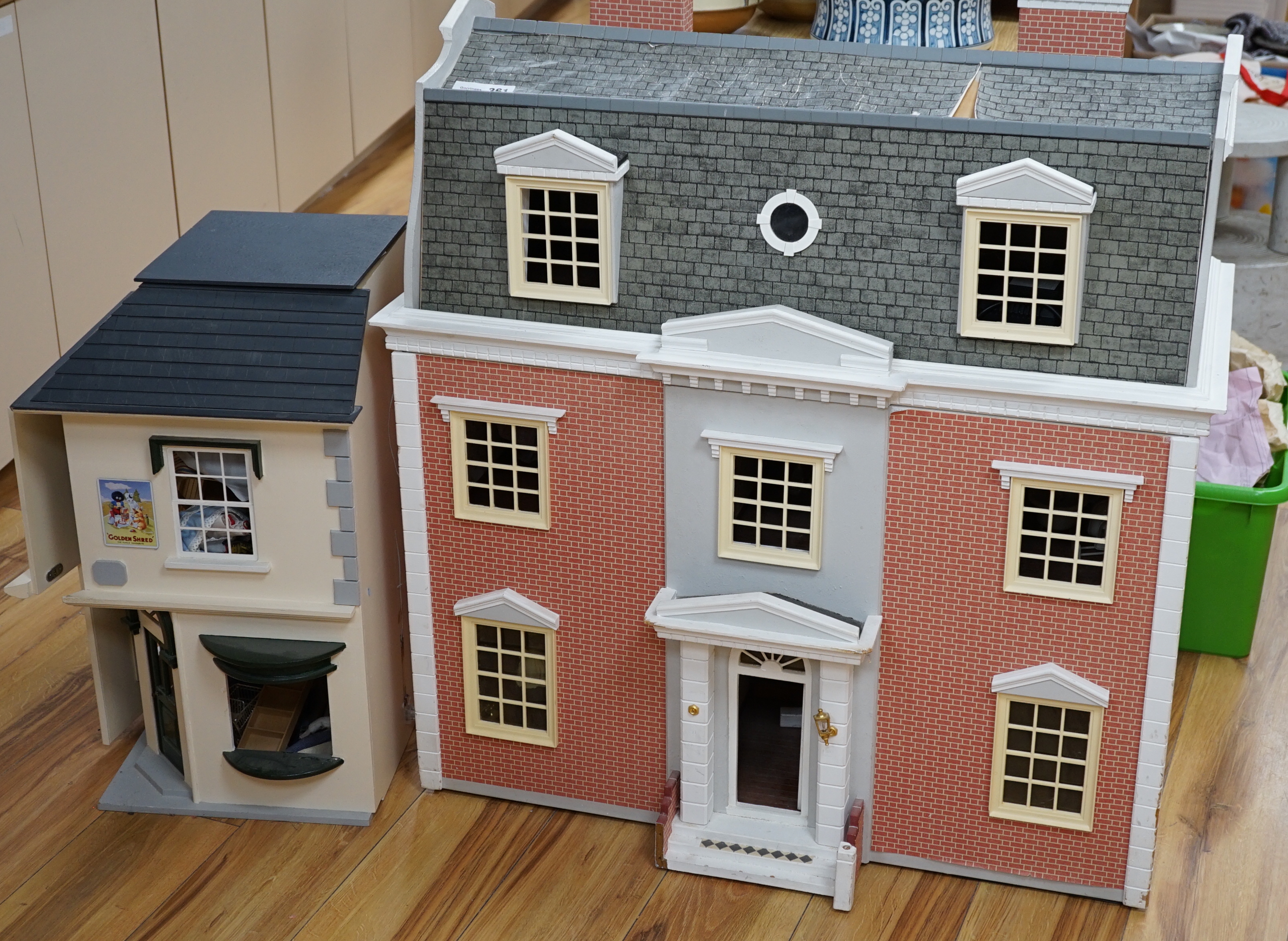 A modern Georgian style dolls house, with two front opening doors, containing six rooms with furnishings, figures, and electric lighting, together with a dolls shop, containing two rooms, furnishings, and accessories, et